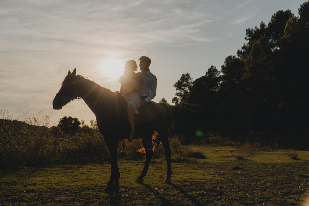 Pareja paseando a caballo en una sesión de fotos natural